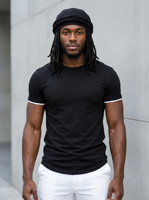 Man with locs wearing the black halo turban, black tee and white pants