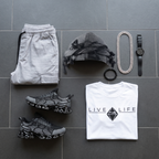 Flat-lay of the grey twist turban with tassels, LIVE LIFE tee, grey cargo joggers, sneakers and chain