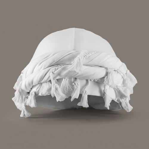 White cotton halo turban with tassel trim on a grey backdrop