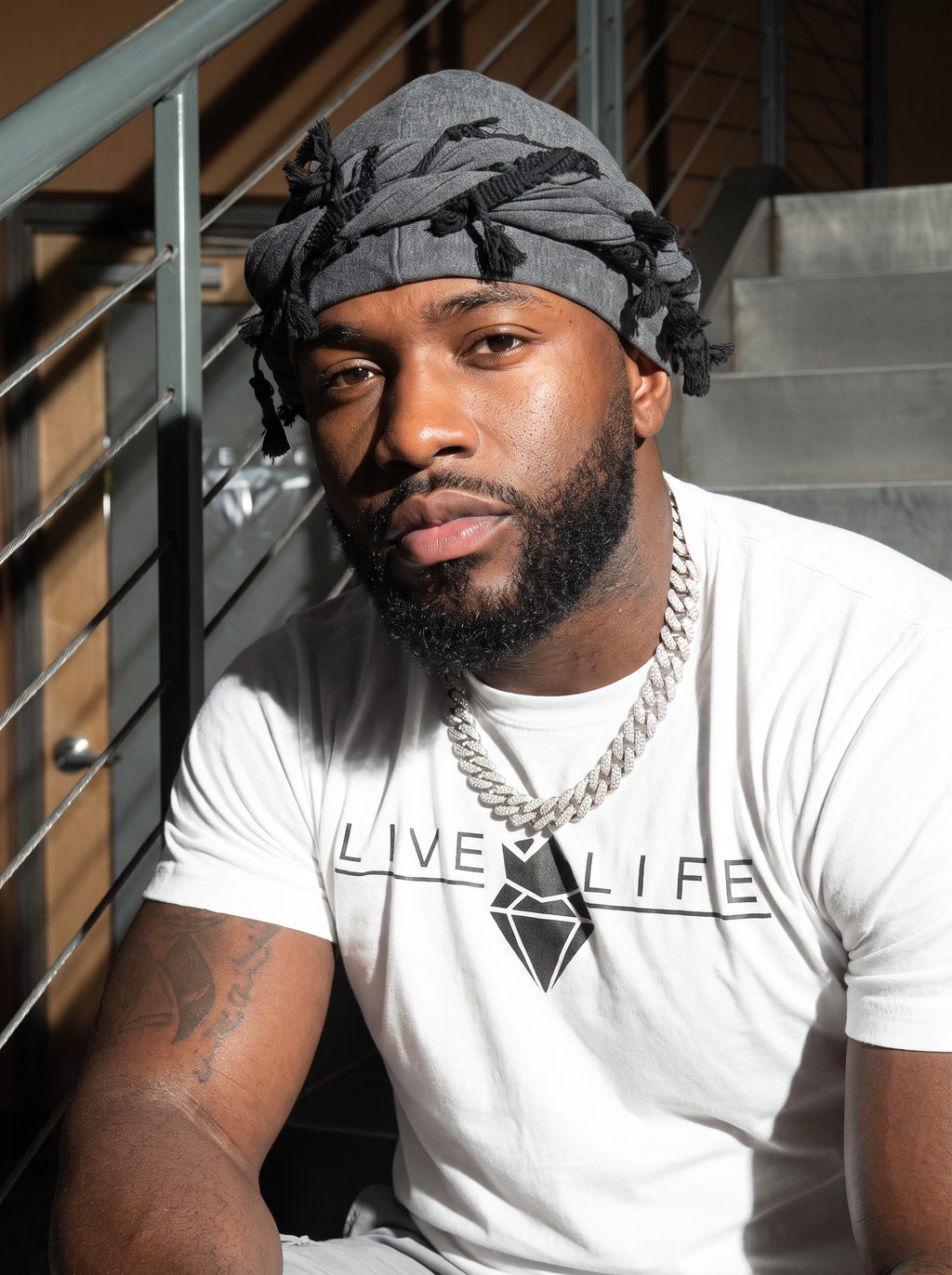 Portrait of a man wearing the charcoal grey twist turban with tassels